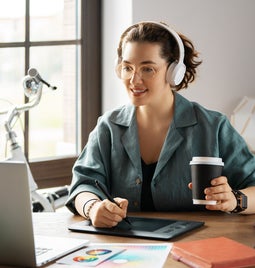 woman at home office with drawing tablet and coffee
