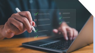 Businessman working on laptop computer comparing checklists