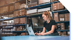 Woman working at a laptop in a warehouse