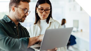 Man and woman discussing in front of a laptop