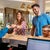 Hotel receptionist hands smiling family a room key