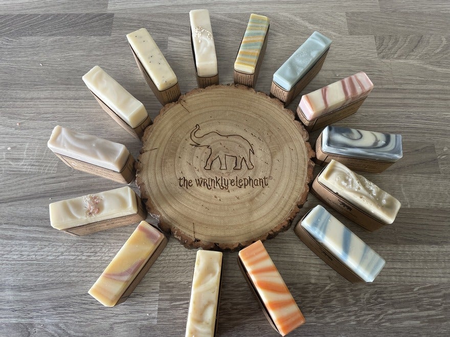 Natural Soap Range (1) Circle of soap bars displayed around a circle of wood with The Wrinkly Elephant engraved into the wood