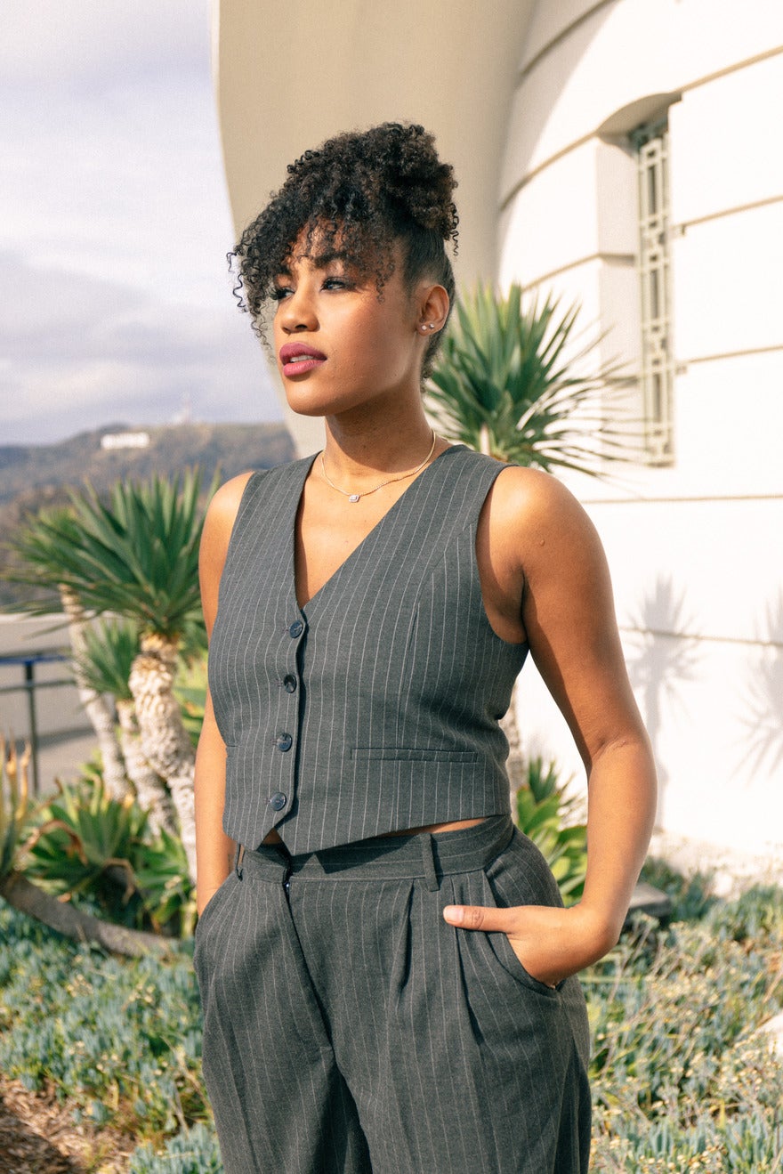 SHONTEL_2022_portrait_-6572 (1) (2) (1) Shontel Horne standing in front of palm trees wearing a grey suit