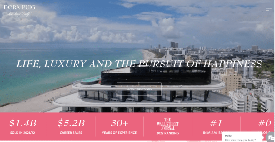 DP Luxury real estate homepage for Dora Puig featuring a coastal view, with a motto "Life, Luxury and the Pursuit of Happiness," and key achievements.